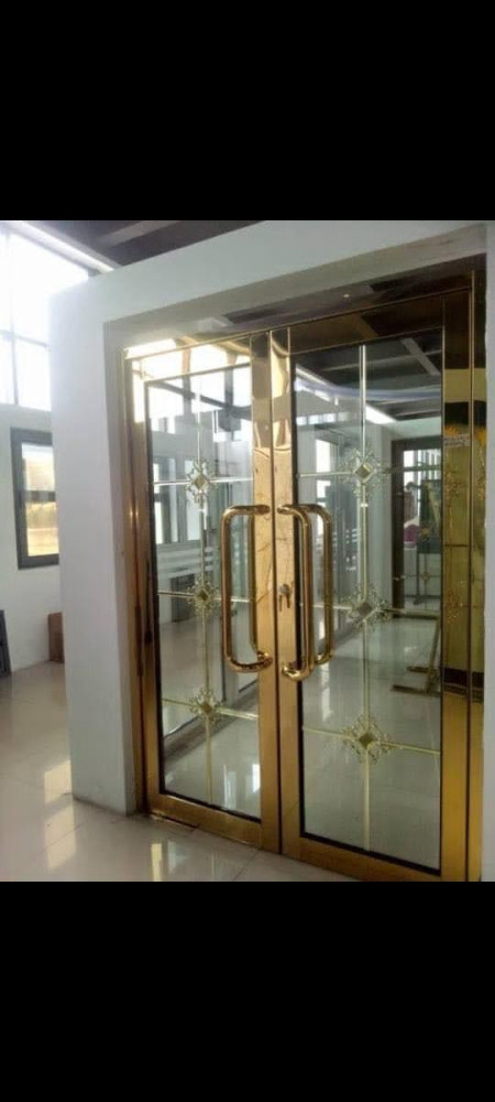 Frameless glass door with a gold-coloured stainless steel frame and matching handles