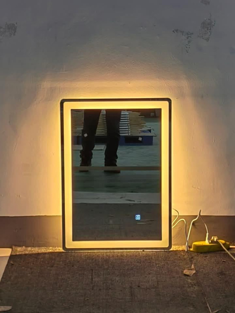 Reflection of a person standing on a floor in an industrial or warehouse setting